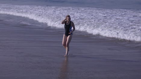 Weiße-Frau-Mittleren-Alters-Läuft-In-Zeitlupe-Aus-Dem-Pazifischen-Ozean-In-Venice-Beach,-Kalifornien