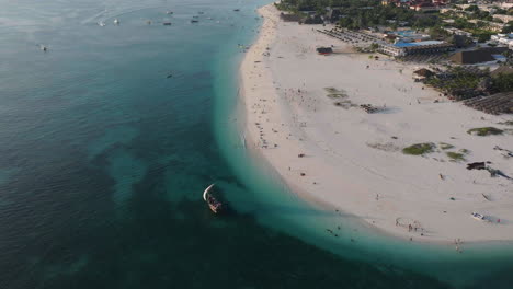 Aerial-view-of-tourists-boats-sails-near-the-wonderful-beach-of-Zanzibar,-shot-at-30-fps