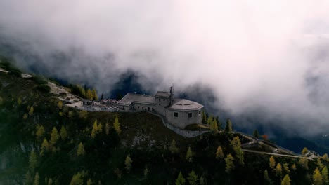 Luftaufnahme-Einer-Majestätischen-Steinburg-Auf-Einem-Berggipfel,-Eingehüllt-In-Nebel