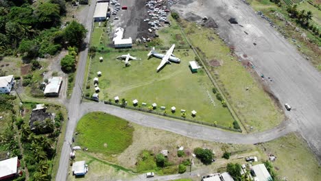 Stillgelegte-Flugzeuge-Am-Pearls-Airport-In-Grenada,-Sonniger-Tag,-Luftaufnahme