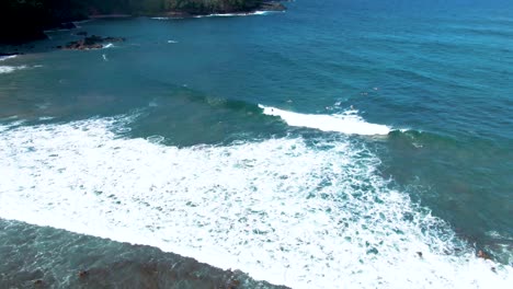 Toma-Aérea-En-órbita-De-Un-Surfista-Montando-Una-Ola-En-La-Playa-De-Koki-En-La-Costa-De-Maui