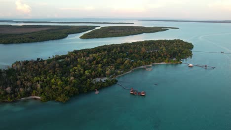 Vista-Aérea-De-Pájaro-De-La-Isla-Leebong-Con-Complejos-De-Bungalows-Conectados-Sobre-El-Agua-Al-Atardecer,-Belitung-Indonesia