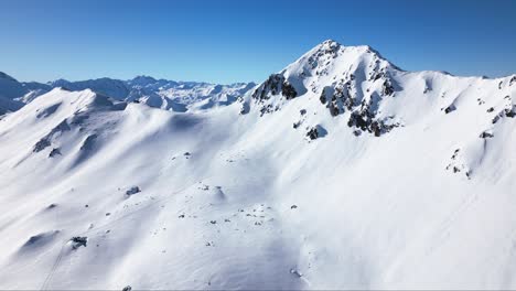 Eine-Wunderschöne-Weiße-Winterlandschaft-Mit-Endlosen-Großen-Bergen,-Einem-Blauen-Himmel-Und-Einem-Weiten-Horizont