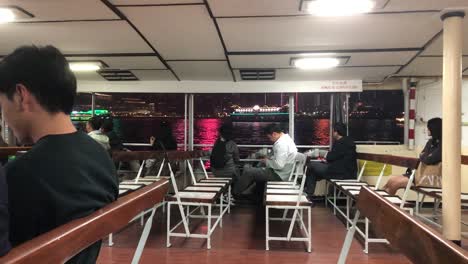 People-look-out-the-from-the-old-ferry-at-night-onto-Causeway-Bay-in-Hong-Kong