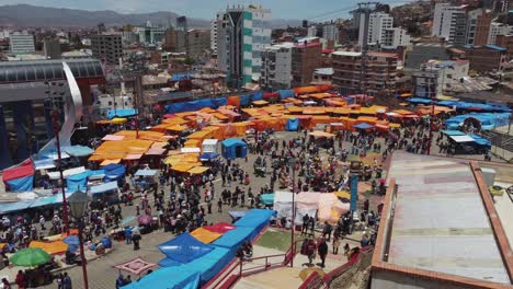 Cable-cars-glide-over-busy-plaza-during-Carnival-in-Oruro,-Bolivia