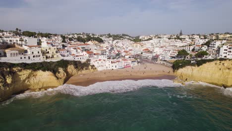Aerial-orbit-town-Carvoeiro,-Portugal-on-the-algarve-coast,-famous-tourist-beach