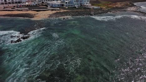 Luftaufnahme-Des-Meeres-In-Der-Nähe-Der-Hotelzone-Am-Strand-Von-Corralejos,-Fuerteventura,-Kanarische-Inseln