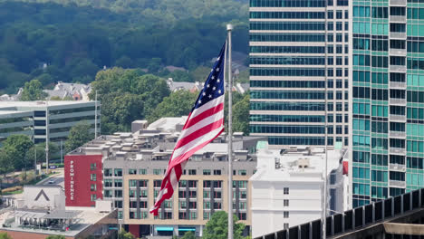 Bandera-Americana-Moviéndose-En-El-Viento-Frente-A-Edificios-De-Oficinas