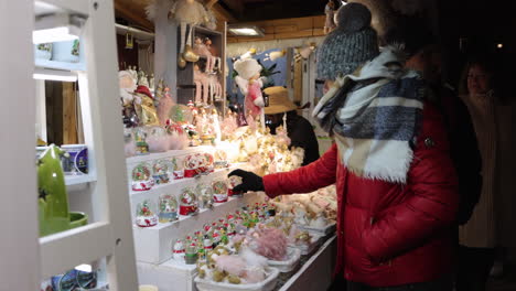 Frau-Schaut-Auf-Schneekugel-Auf-Dem-Weihnachtsmarkt-In-Budapest---Mittlere-Aufnahme