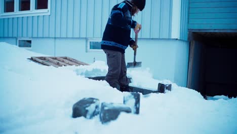 Man-Clearing-Snow-Off-With-Shovel-During-Winter---Wide-Shot
