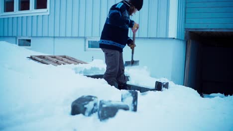 Hombre-Quitando-La-Nieve-Con-Una-Pala-Durante-El-Invierno---Plano-Amplio