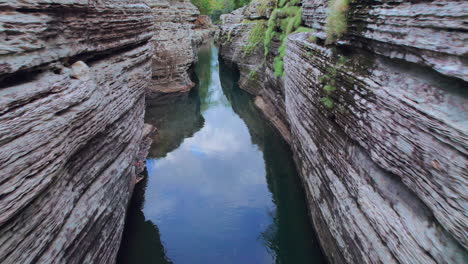 Tranquil-waters-flow-through-the-narrow-Cajones-de-Chame-canyon-in-Panama,-lush-greenery-speckling-the-cliffs