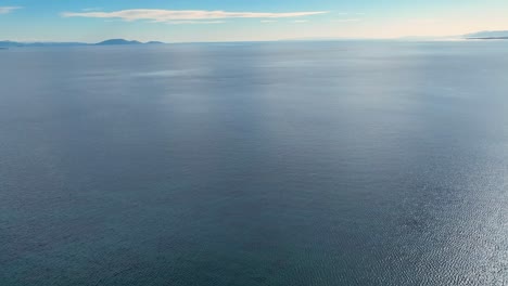 Drone-footage-over-the-calm-sea-with-clouds