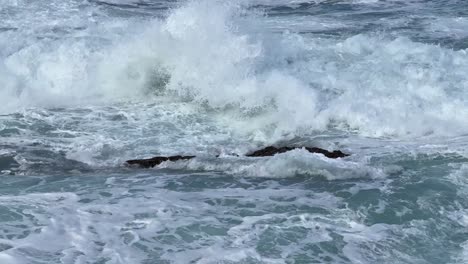 Ocean-waves-crashing-and-spraying-high-together-during-King-tide-over-blue-ocean-and-blue-sky