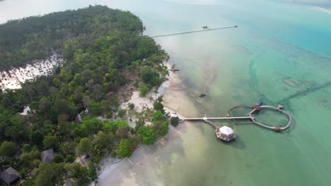 Aerial-Descending-Towards-Leebong-Island's-Over-Water-Bungalows-Resort-with-Long-Wooden-Piers-Over-Emerald-Sea-in-Belitung-Indonesia