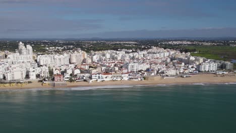 Aerial-View-Of-Armacao-De-Pera-Beach-With-White-Buildings-In-Background