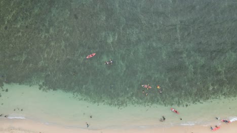 Top-view-of-people-swimming-and-kayak-on-white-sandy-beach