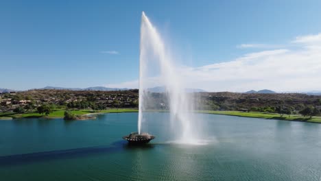 Drone-rises-along-large-grand-fountain-of-water-in-green-community-of-Arizona