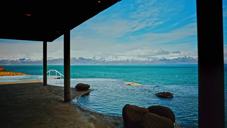 Outdoor-Icelandic-thermal-spa-with-breathtaking-view-of-the-nordic-ocean-and-majestic-snowy-mountains-the-distance