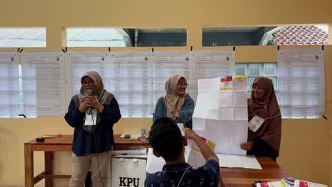 Funcionarios-Electorales-Indonesios-Contando-Votos-En-Una-Oficina-Luminosa,-A-La-Luz-Del-Día