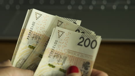 Weibliche-Hände-Zählen-200-Polnische-Zloty-Scheine---Enge-Nahaufnahme