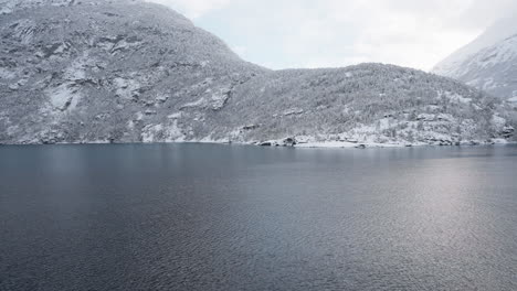 Slow-motion-POV-of-a-winter-ferry-boat-ride-in-Geirangerfjord-to-Geiranger,-Norway,-with-snowy-mountains-and-captivating-fjord-views