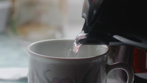 Zeitlupenaufnahme-Von-Wasser,-Das-Aus-Einem-Wasserkocher-In-Eine-Kaffeetasse-Fließt