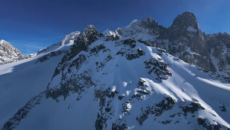 Aerial-view-of-snow-mountain-peak-in-french-alps-on-a-sunny-day,-clear-blue-sky,-Mont-Blanc,-Chamonix