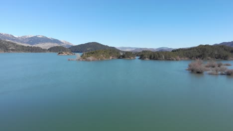 Antena-Rápida-Sobre-El-Lago-Artificial-De-Montaña-Soleado-Día-De-Invierno