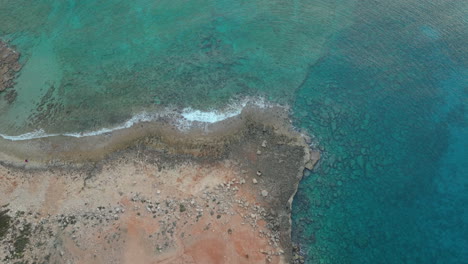 Aerial-top-down-shot-of-crystal-clear-sea-water-with-rocks-underwater-at-Ayia-Napa
