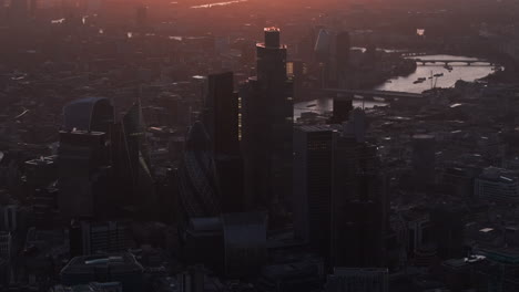 Dunkle,-Kreisende-Luftaufnahme-Der-Wolkenkratzer-Der-City-Of-London-Bei-Sonnenuntergang