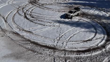 Drone-image-of-an-SUV-vehicle-drifting-in-snowy-terrain