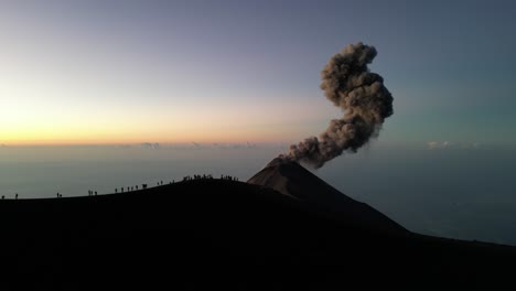 Drohnenansicht-In-Guatemala,-Die-über-Einen-Vulkankrater-Fliegt,-Mit-Einem-Ausbrechenden-Vulkan-Bei-Sonnenaufgang,-Menschen-Auf-Dem-Rand,-Umgeben-Von-Wolken