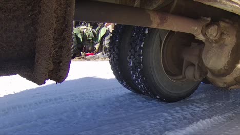 Heavy-duty-driveshaft-and-differential-on-a-grain-truck-moving-around-a-snowy-farmyard