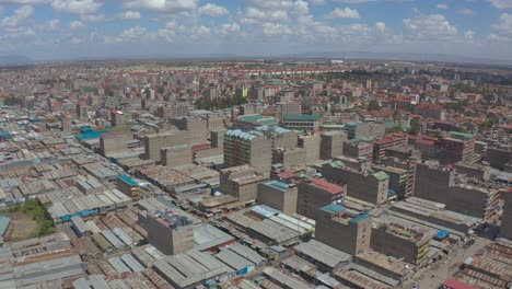 Eine-Drohnenaufnahme-Von-Kware,-Einem-ärmeren-Viertel-In-Nairobi,-Mit-Verrosteten-Blechdächern-Und-Hochhäusern