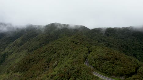 Drohnenansicht-über-Einem-Riesigen-Bergwald-Mit-Einer-Kurvenreichen-Straße,-Die-Von-Wolken-Bedeckt-Ist,-La-Gomera,-Spanien