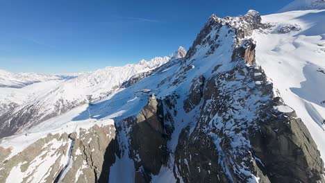 Vista-Aérea,-Picos-Nevados-De-Los-Alpes-Franceses-En-Un-Día-Soleado-Con-Cielo-Azul-Claro-En-La-Región-De-Chamonix