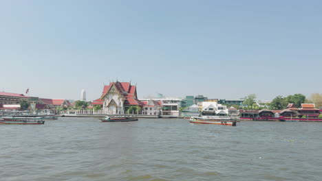 Paseo-En-Barco-Por-El-Río-Chao-Phraya-Bangkok,-Tailandia,-Templos-Cerca-Del-Banco-De-Agua-Prores