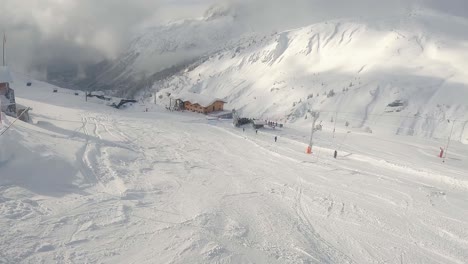 Noch-Immer-Geschossen-Mit-Blick-Auf-Den-Skilift-Und-Die-Skifahrer,-Die-An-Einem-Sonnigen-Tag-Den-Berg-Hinunterfahren