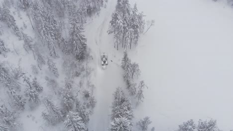 Vista-Aérea-De-Un-Tractor-Conduciendo-Sobre-Una-Naturaleza-Cubierta-De-Nieve