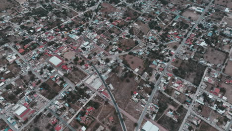 Drone-footage-of-Nopaltepec,-Mexico,-capturing-city-scenes-with-cars,-houses,-buildings,-streets,-and-trees-in-a-rural-setting