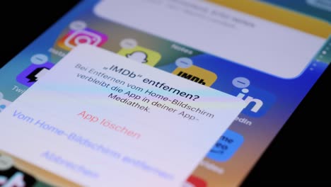 Deinstallieren-Der-IMDB-App-Aus-Dem-App-Store-Des-IPhone-Per-Fingerberührung,-Statische-Nahaufnahme