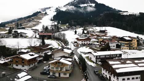Homes-of-Kirchberg-town-in-Austria-in-winter-season,-aerial-ascend-view