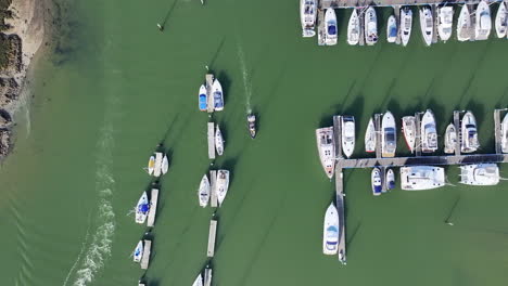 Aerial-shot-birds-eye-view-tracking-boat-leaving-boatyard-4K