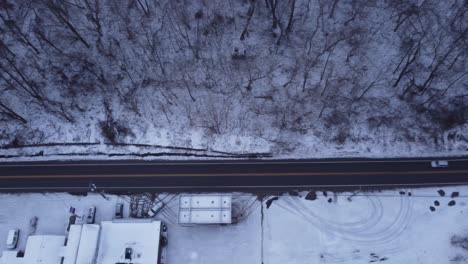 Drone-flying-over-a-road-as-a-car-drives-by