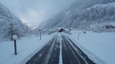 POV-Spaziergang-Im-Verschneiten-Lauterbrunnen,-Schweiz,-Der-Den-Charme-Des-Winters-Mit-Fallendem-Schnee-Und-Majestätischer-Aussicht-Auf-Die-Berge-Im-Tal-Zeigt