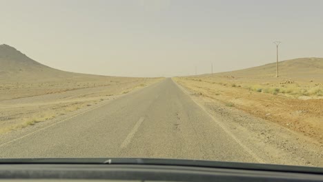 POV-of-a-caravan-traveling-on-a-straight-desert-road-in-Merzouga-in-Morocco