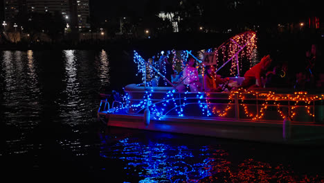 Menschen-Auf-Dekorierten-Beleuchteten-Motorboot-Bei-Nacht,-Tampa-Weihnachtsbootparade,-Florida