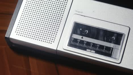 Nahaufnahme-Eines-Vintage-Kassettenrekorders,-Der-Auf-Einer-Hölzernen-Tischplatte-Liegt-Und-Eine-Kassette-Abspielt