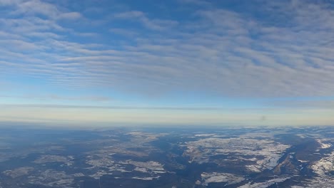 Vista-Aérea-Panorámica-De-Los-Bosques-Nevados-Desde-La-Ventana-Del-Avión-En-Un-Día-Claro-Y-Soleado